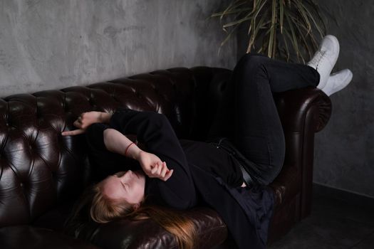 portrait of beautiful confident brunette woman in black in grey dark room. business woman. feminine. millennial people. stylish fashion clothes.