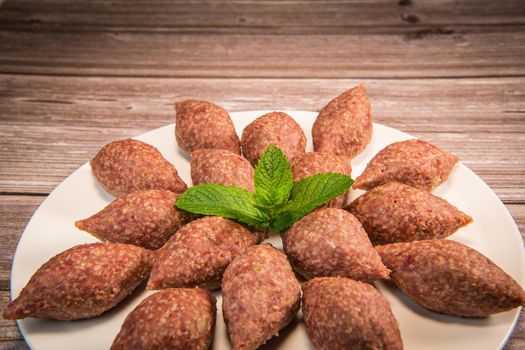 Traditional kebbe and pita bread on big round plate in lebanese restaurant. High quality photo