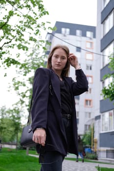 pretty brunette woman on background of bright modern buildings. feminine. millennial people. lady on walk.