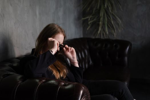 portrait of confident woman in black in dark room. pensive serious people. business woman. feminine. millennial people.