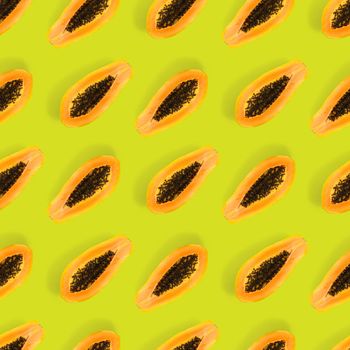 Fresh ripe papaya seamless pattern on green background. Tropical abstract background. Top view. Creative design, minimal flat lay concept. Trend tropical fruit food background pattern