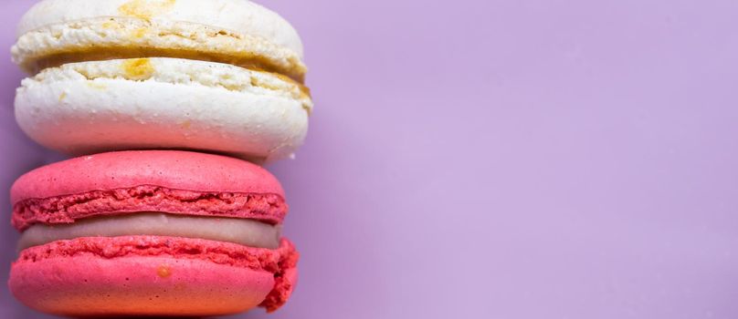 Colorful french cookies macarons set on pink background. Tasty fruit, almond sweet cookies, cake macaron. Holiday backdrop design.