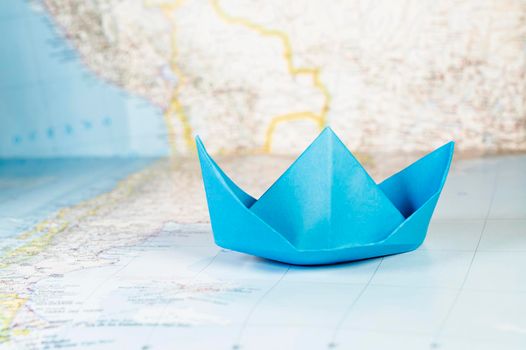 Beautiful blue paper boat on world map ,