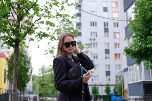 pretty brunette woman on background of bright modern buildings. feminine. millennial people. lady on walk.