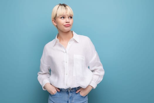 young pretty blond secretary woman dressed in a white shirt on a blue background with copy space.