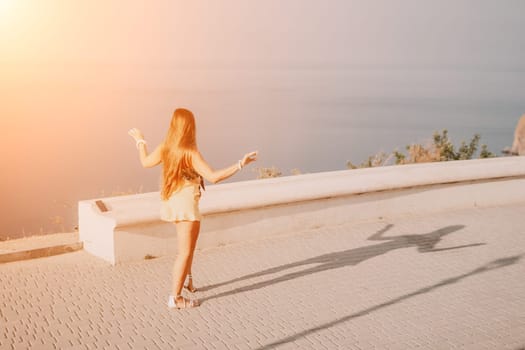 silhouette of a happy woman who dances, spins and raises her hands to the sky. A woman is enjoying a beautiful summer day.