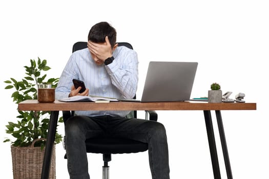 sad businessman working with laptop and having phone conversation with client