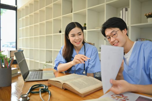 Medical student preparing for university exams, discuss patient diagnosis in library. Medical internship concept.