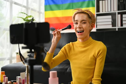 Young queer man beauty make up artist or vlogger recording makeup tutorial in home studio. LGBTQ lifestyle, influencer, blogger.