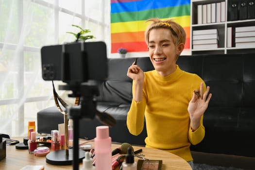 Young queer man beauty make up artist or vlogger recording makeup tutorial in home studio. LGBTQ lifestyle, influencer, blogger.