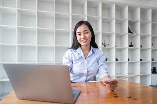 Asian businesswoman working for financial graphs showing results about their investments, planning successful business growth process by laptop computer.