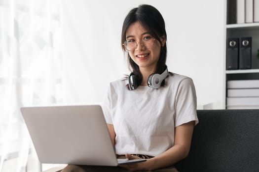 Beautiful young asian student girl using a laptop computer learning online at home. Online learning education..