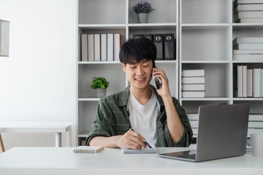 Young student busy study make notes in notebook and using laptop concentrated online training course technology education..