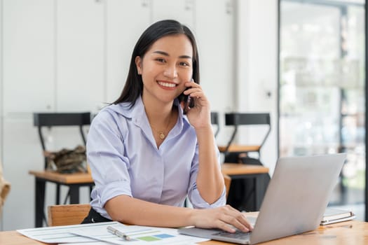 Portrait of happy young office assistant working remotely online sitting with laptop..