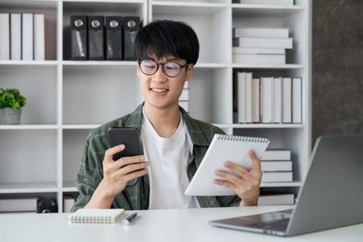 Young student busy study make notes in notebook and using laptop concentrated online training course technology education..