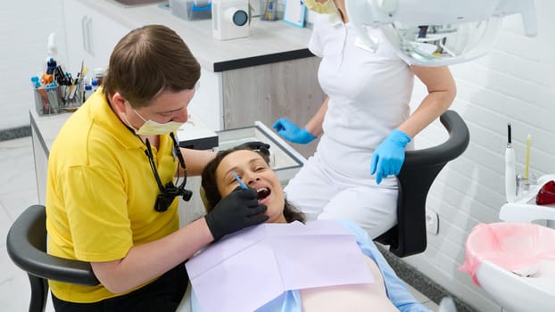 Multi ethnic female pregnant patient, gravid woman in dentist's chair, receiving examination of teeth and oral cavity for prevention caries and inflammation during pregnancy, in dentistry clinic