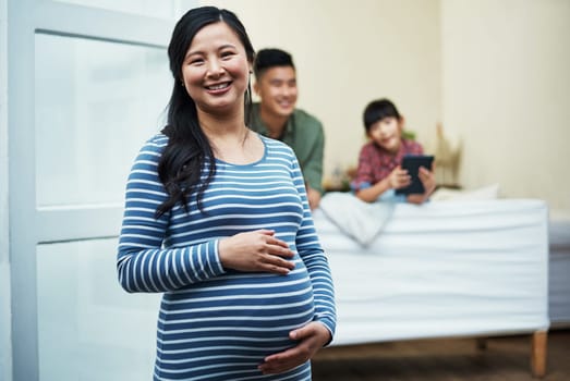 Well soon be a family of four. Portrait of a pregnant woman relaxing with her family at home