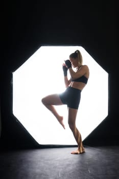 Woman Boxer In Gloves Training On a black, red, yellow Background