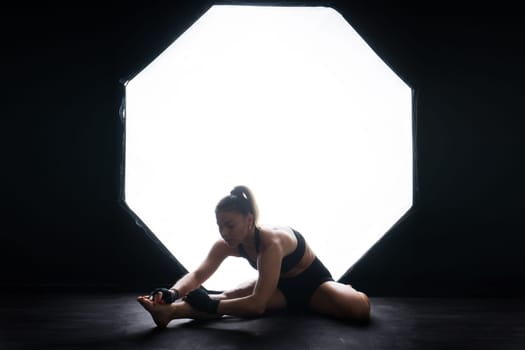 Woman Boxer In Gloves Training On a black, red, yellow Background