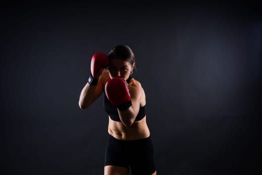 Woman Boxer In Gloves Training On a black, red, yellow Background