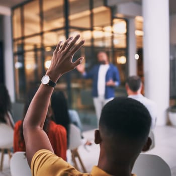 Hes got a curious mind. an unrecognizable businessperson raising their hand to ask a question during a conference at work