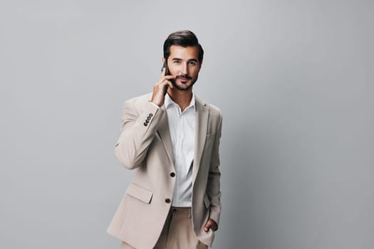 man phone suit call businessman success message young selfies beige happy business background hold smile confident smartphone cellphone white cell portrait