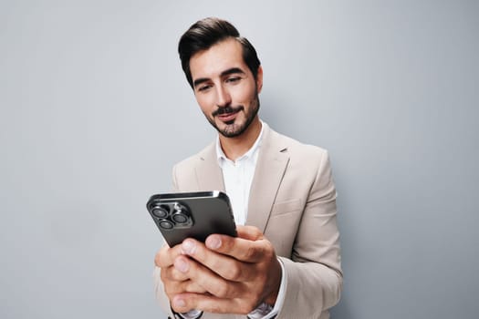 male man handsome businessman application blogger smile suit hold cell gray portrait studio success call smartphone adult happy business phone confident