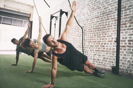 You have to change your lifestyle in order to see results. a fitness group doing the side plank together at the gym