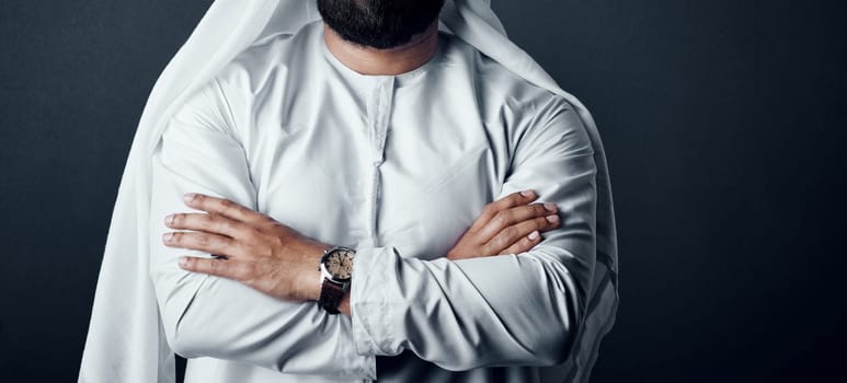 Be ready for business and it will be ready for you. Studio shot of an unrecognizable man dressed in Islamic traditional clothing posing against a dark background