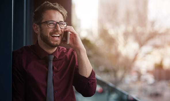 Good communication skills are essential for business success. a young businessman using a mobile phone on the balcony of an office