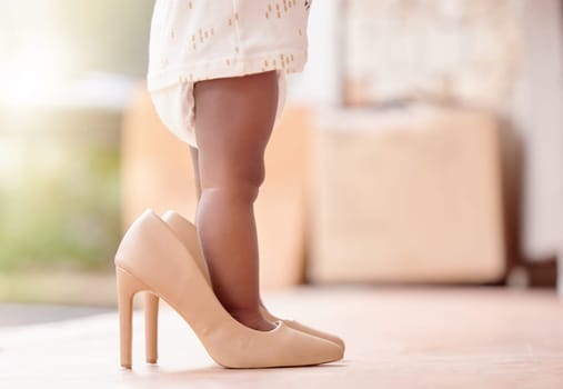 Closeup, baby and girl with high heels shoes in home for childhood growth, toddler and adorable kid. Legs, infant and feet of little child in big footwear for pretend playing, development and walking.