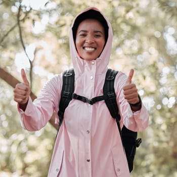Black woman, portrait smile and hiking with thumbs up for success, winning or achievement in nature. Happy African female person or hiker smiling and showing thumb emoji, yes sign or like in trekking.