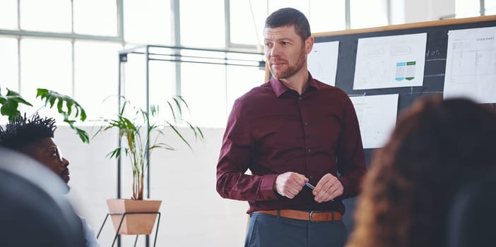 Hes an exceptional leader. a businessman giving a presentation to his colleagues in an office