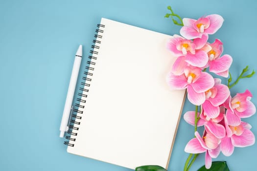 Blank open notebook and pink color orchid for your text or message.