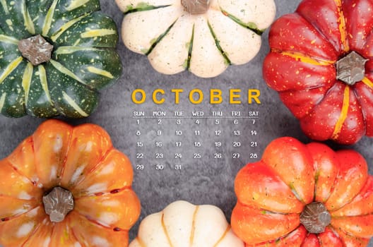 October 2023 Calendar and pumpkins with autuma leaf on old wood background.