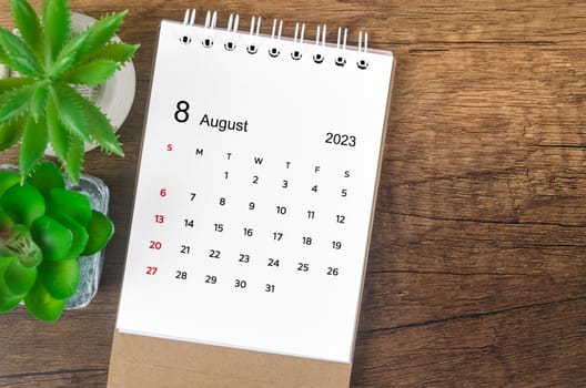 August 2023 desk calendar for 2023 on wooden background.