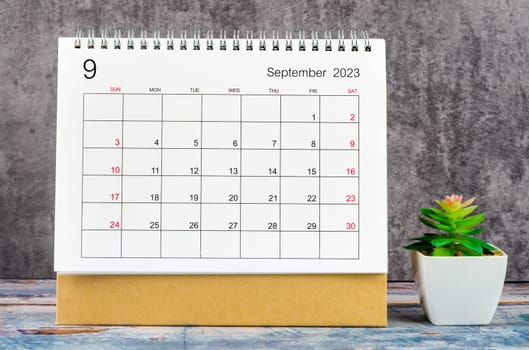 September 2023 Monthly desk calendar for 2023 year with plant pot on wooden table.