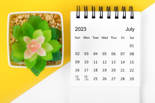 July 2023 Monthly desk calendar for 2023 year with small tree on yellow background.
