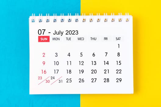 July 2023 Monthly desk calendar for 2023 year on blue and yellow background.