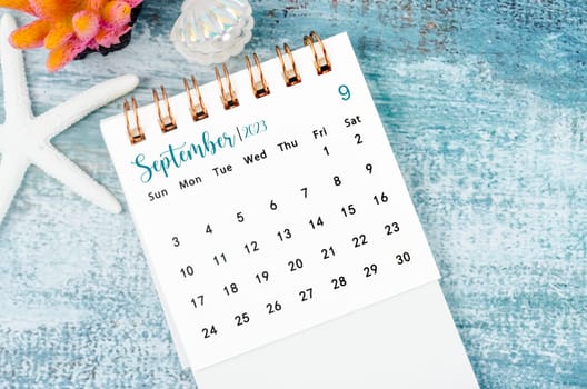 September 2023 Monthly desk calendar for 2023 year on old blue wooden background.
