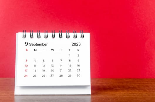 September 2023 desk calendar for 2023 year on Red color background.