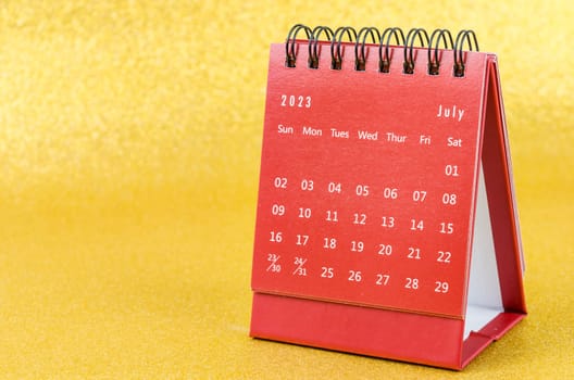 Red July 2023 Monthly desk calendar for 2023 year on golden color background.