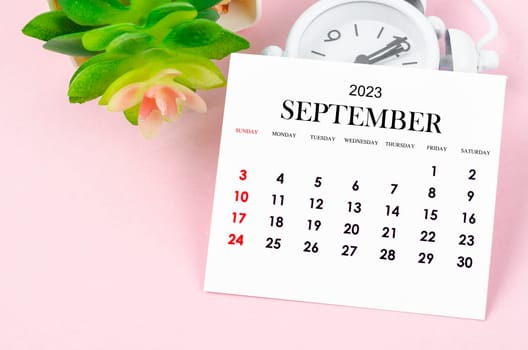 September 2023 Monthly calendar for 2023 year with vintage alarm clock on pink colour background.