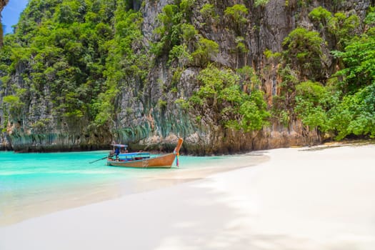 Thai traditional wooden longtail boat and beautiful beach in Phuket province, Thailand.