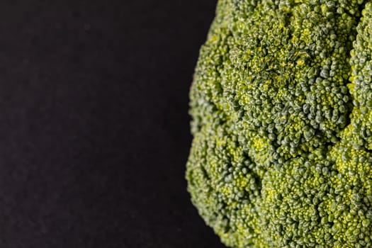 Extreme close-up of fresh green broccoli on black background with copy space. unaltered, vegetable, healthy food, raw food and organic concept.