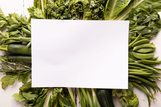 Overhead view of various green vegetables on white table with copy space. unaltered, food, organic, advertisement, healthy eating.