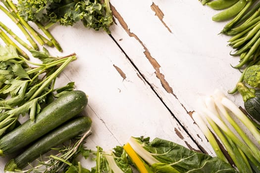 Overhead view of fresh organic green vegetables on white table, copy space. unaltered, food, organic, healthy eating.