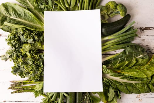 Overhead view of fresh green vegetables on white table with copy space. unaltered, food, organic, advertisement, healthy eating.