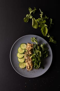 Overhead view of fresh healthy food in plate on black background, copy space. unaltered, food, studio shot, healthy eating, organic.