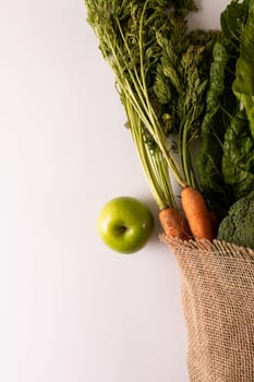 Overhead view of fresh vegetables and fruit with burlap on white background, copy space. unaltered, food, healthy eating, organic.